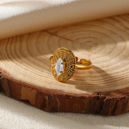 Gold ring with a central gemstone on a wooden surface