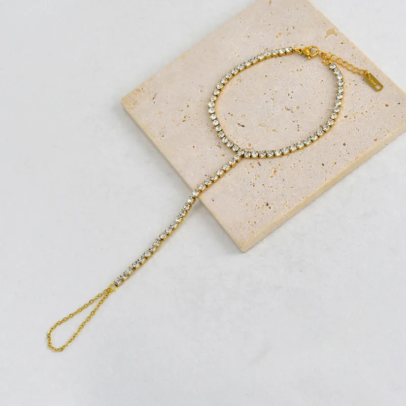 Gold headband with crystals on a beige card against a light gray background