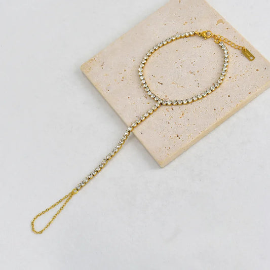 Gold headband with crystals on a beige card against a light gray background