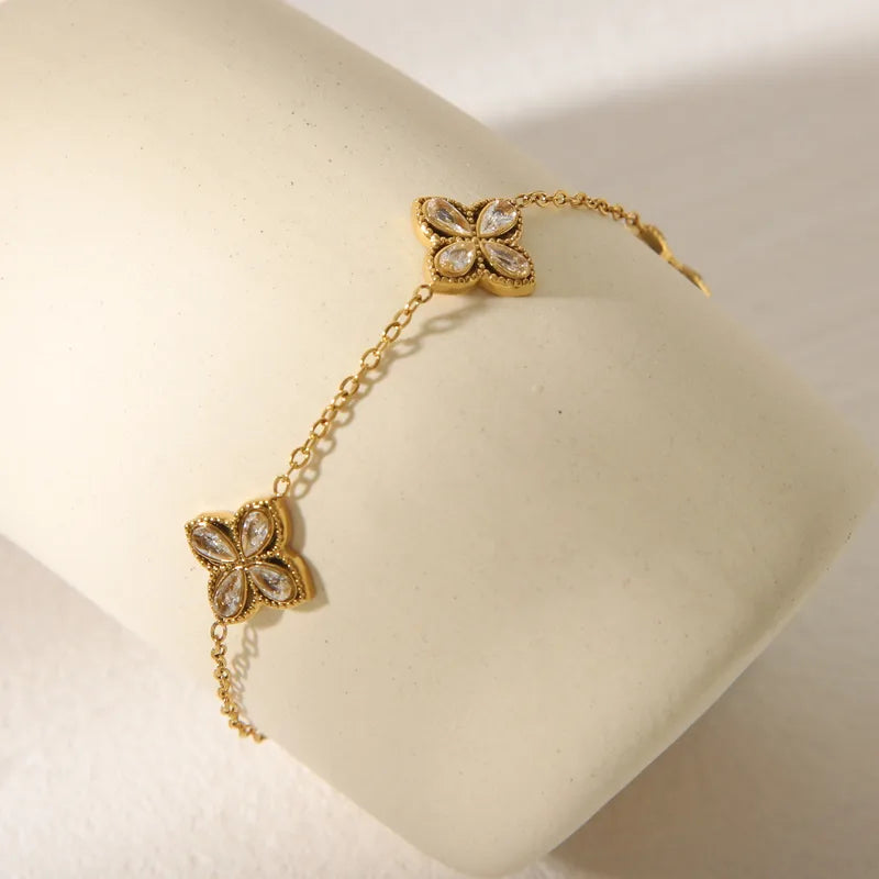 Gold bracelet with floral designs on a white cushion