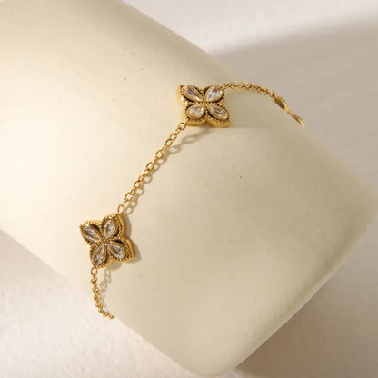 Gold bracelet with floral designs on a white cushion