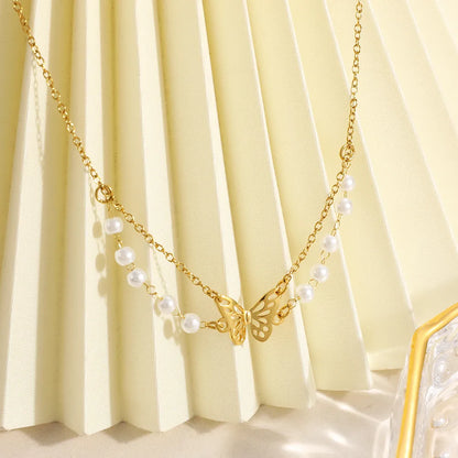 Gold necklace with butterfly pendant on a yellow fabric background