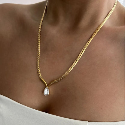 Gold chain necklace with Tear drop diamond pendant on a person