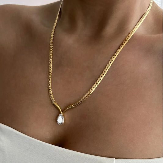 Gold chain necklace with Tear drop diamond pendant on a person