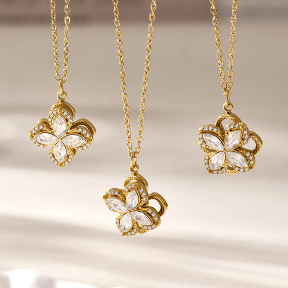 Three gold butterfly necklaces with gemstones on a neutral background