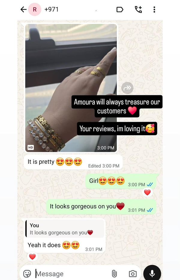 Text conversation with a hand wearing gold jewelry on a phone screen