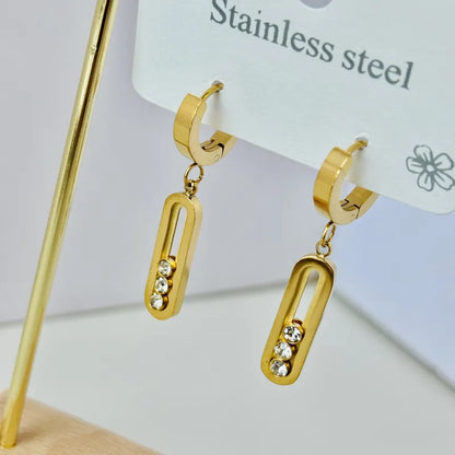 Gold hoop earrings with dangling rectangular charms on a white background