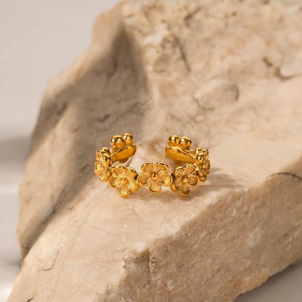 Gold floral ring on a stone surface