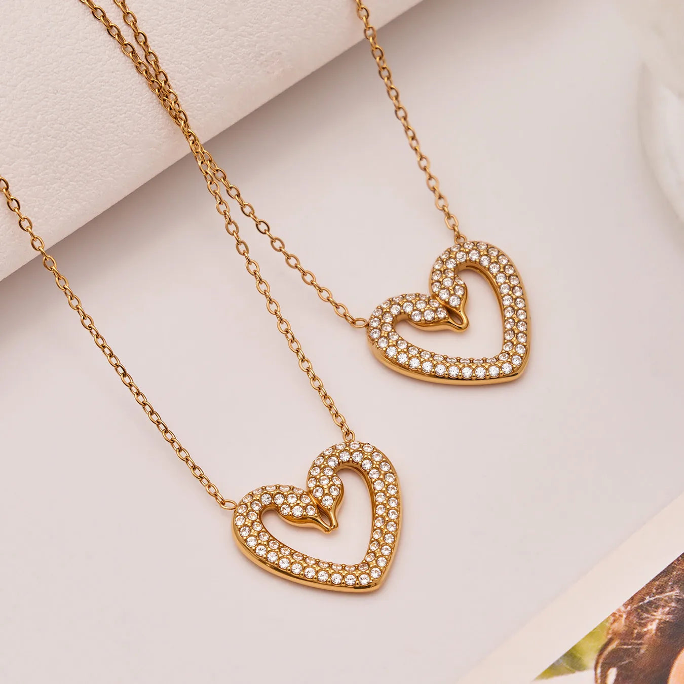 Gold heart-shaped necklace with embedded stones on a light background