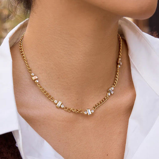 Gold chain necklace on a person wearing a white shirt