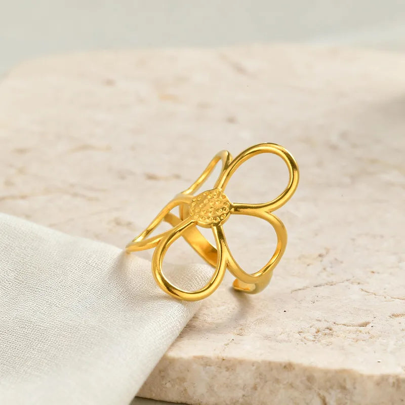 Gold bow-shaped ring on a light beige fabric background