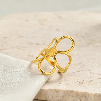 Gold bow-shaped ring on a light beige fabric background